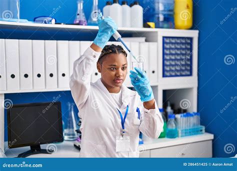 African American Woman Scientist Pouring Liquid On Test Tube At