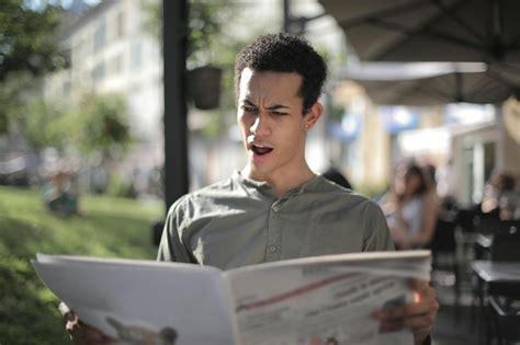 Shallow Focus Photo of Man Reading NewspaperFree Stock Photo