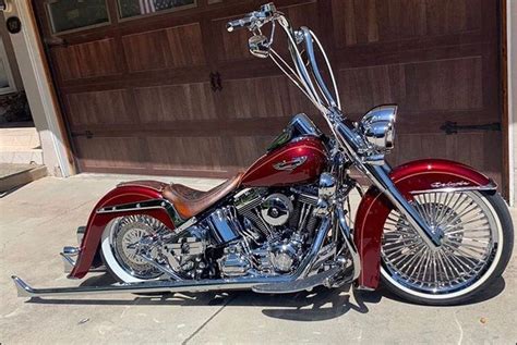 a red motorcycle parked in front of a garage