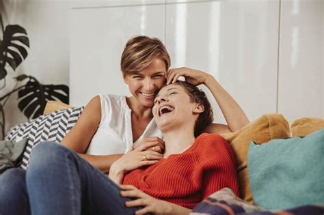 Premium Photo Happy Lesbian Couple Laughing And Cuddling On Couch