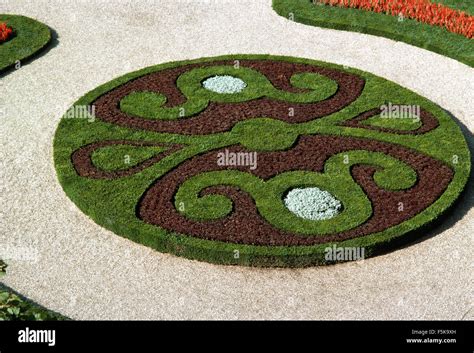 Formal Knot Garden With Circular Bed With Annuals And Closely Mown