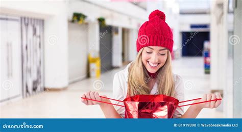 Composite Image Of Pretty Blonde Opening Gift Bag Stock Photo Image