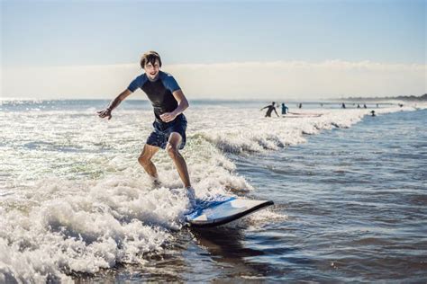 Young Man Beginner Surfer Learns To Surf On A Sea Foam On The B Stock