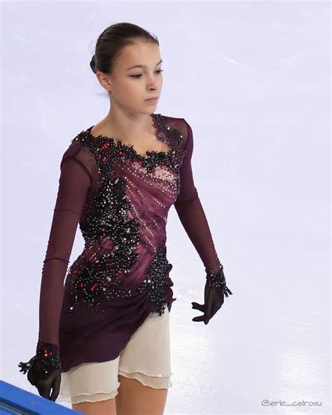 A Female Figure Skating On The Ice In A Short Skirt And Top With Sequins