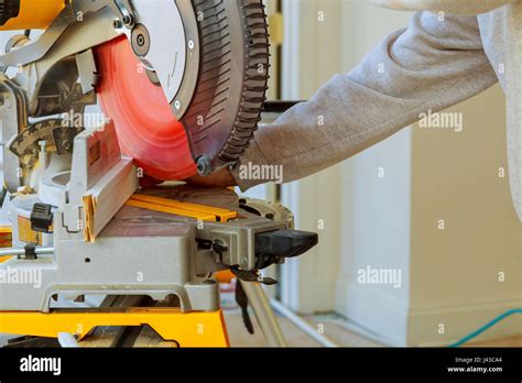 Carpenter Cutting Wooden Plank With Circular Saw Wearing Safety