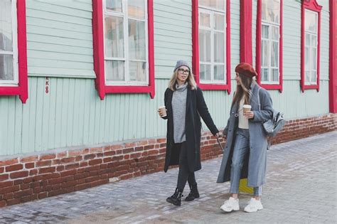 Premium Photo Two Cheerful Tourist Women Smiling And Walking With