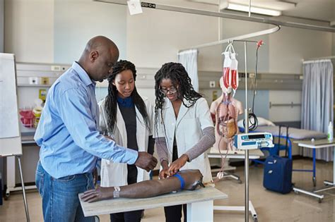 Arzt Unterrichten Weibliche Auszubildende Im Krankenhaus Stockfoto Und