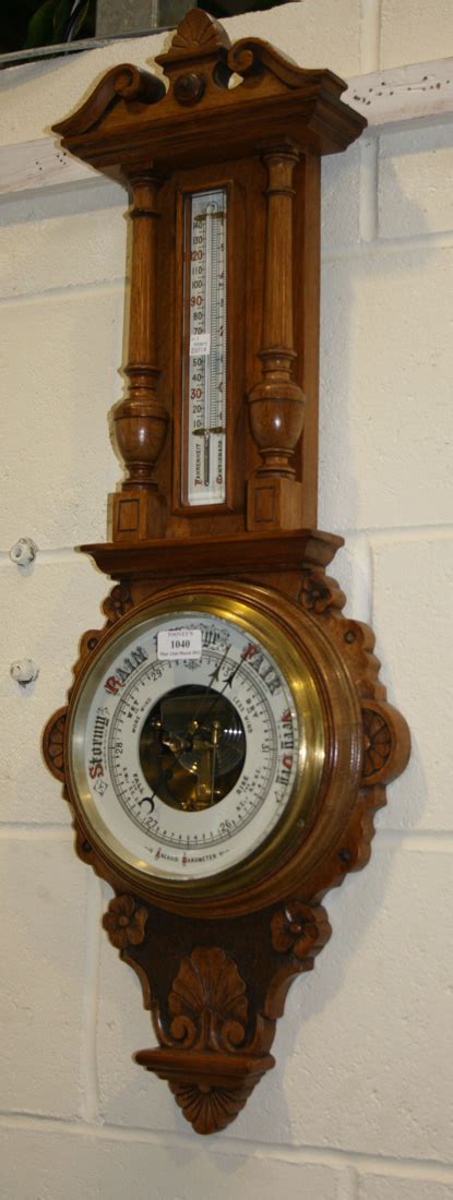 A Late Victorian Oak Wheel Aneroid Barometer With Mercury Thermometer