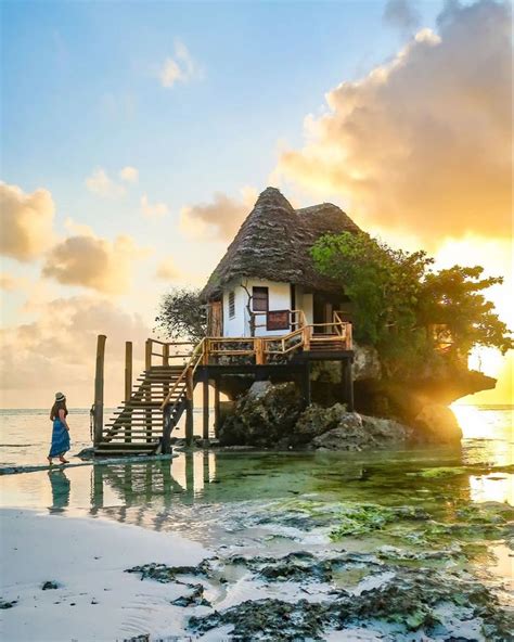 A Small House On An Island In The Middle Of The Ocean With A Woman