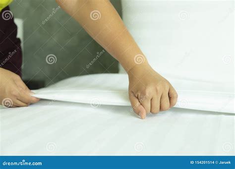 The Housekeeper Is Laying White Sheets In The Bedroom Stock Photo