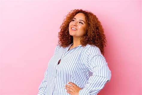 Jovem latina curvilínea isolada na parede rosa relaxada e feliz rindo