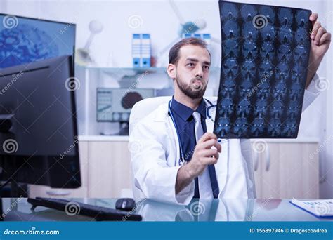 Handsome Neurological Doctor Looking at a Brain Ct Scan in the Cabinet ...