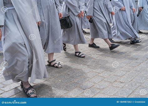 Nuns In Grey Habits Walking On A Stone Cobbled Street Stock Photo