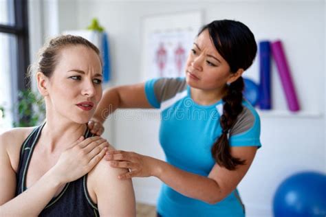 Chinese Woman Massage Therapist Giving A Treatment To An Attractive