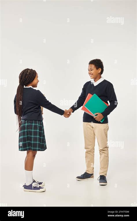 happy african american kids in school uniform holding textbooks and ...