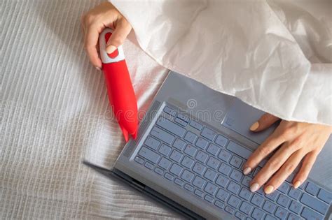 A Woman Lies In Bed Holding A Clitoral Vibrator And Watching On A Laptop The Girl Has Sex