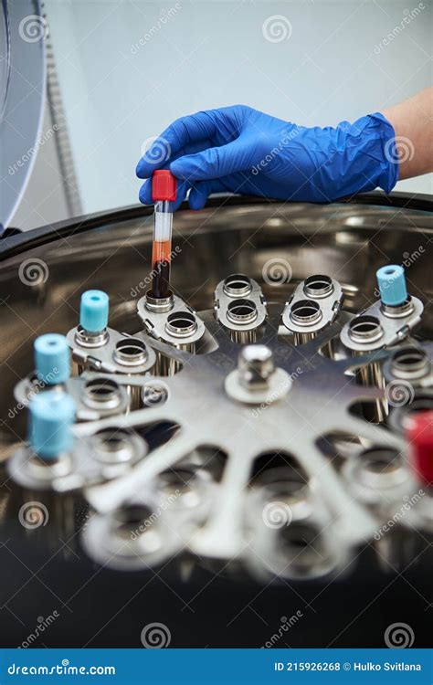 Lab Scientist Placing A Test Tube Into The Centrifuge Machine Stock