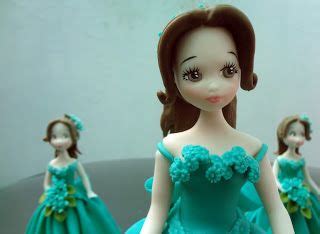 There Is A Doll That Is Wearing A Blue Dress And Three Other Dolls Are