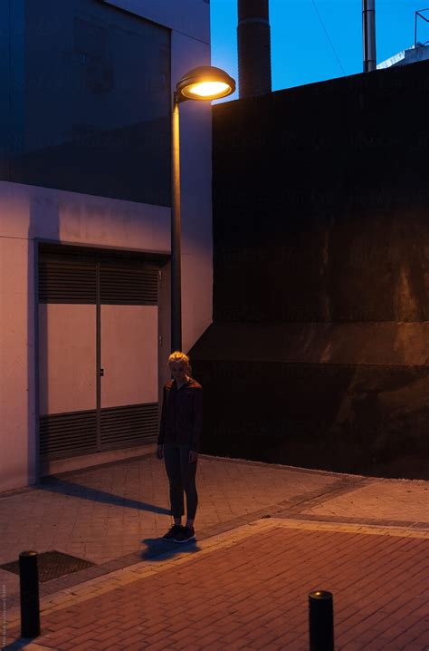 "Sportive Girl Under Burning Street Lamp" by Stocksy Contributor