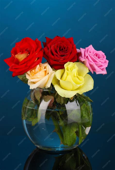 Premium Photo Beautiful Roses In Glass Vase On Blue Background