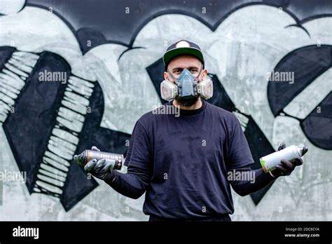 Graffiti Artist Posing In Front Of His Drawing On The Wall With Two