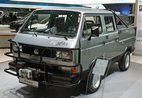 An Old Vw Van Is On Display At A Car Show