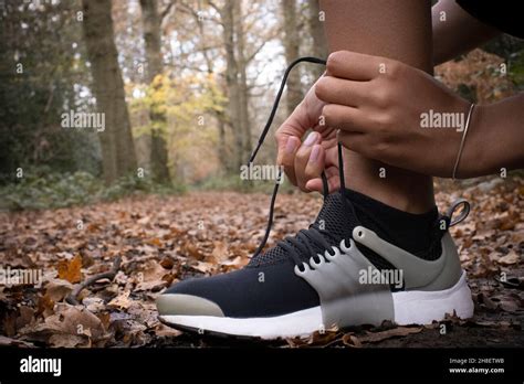 Close Up Female Runner Tying Shoelace In Autumn Woods Stock Photo Alamy