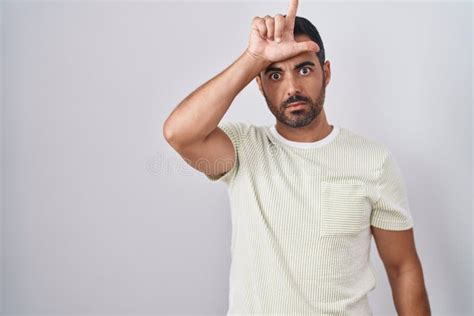 Hispanic Man With Beard Standing Over Isolated Background Making Fun Of People With Fingers On