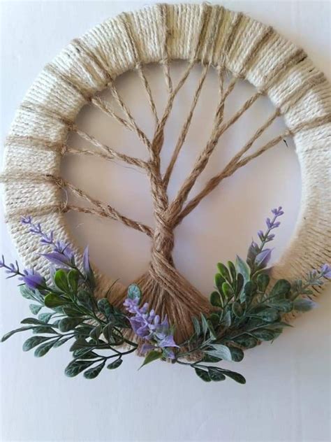 A Wreath Made Out Of Twine And Rope With Purple Flowers On The Front Side