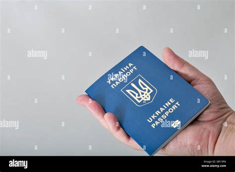 Hand Holding Ukrainian Biometric Passport On White Background Closeup