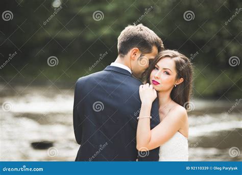 Beautifull Wedding Couple Kissing And Embracing Near The Shore Of A