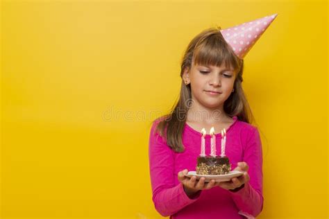 Birthday Girl Making A Wish Before Blowing Candles On A Cake Stock