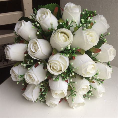 A bridal bouquet featuring artificial silk white roses and gyp ...