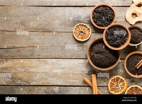 Bowls With Dry Black Tea Leaves Spices And Dried Fruits On Wooden