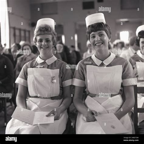 1960s Historical Two Proud Nurses In Uniform Sitting Together At An Award Ceremony For Their