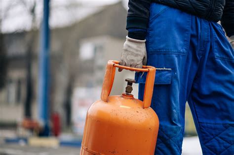 Man Carrying Lpg Gas Bottle At Gas Station Stock Photo Download Image