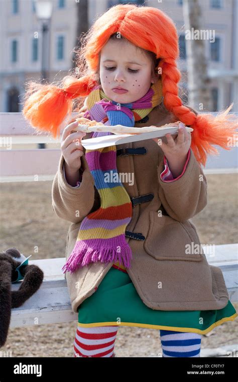 Little girl dressed in Pippi Long stocking eating pizza Stock Photo - Alamy