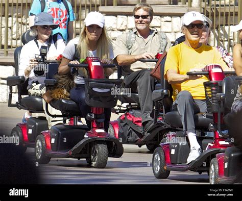 Hugh Hefner And Crystal Hefner Ride Mobility Scooters Through