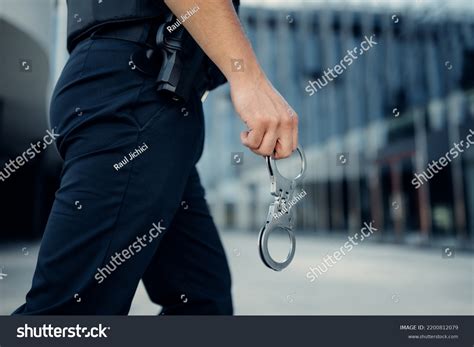 Police Officer Hand Holding Handcuffs Stock Photo 2200812079 | Shutterstock