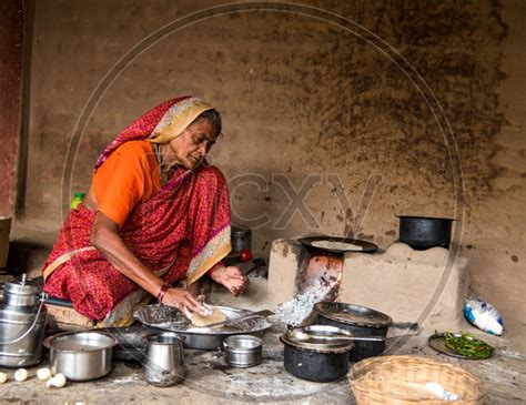 Image Of An Indian Old Woman Making Or Cooking Food In An Ancient Or