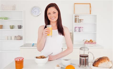 Joven Mujer Bonita Pelirroja Bebiendo Un Vaso De Jugo De Naranja En La