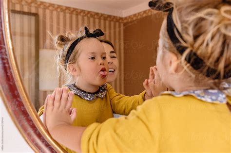 Playful Girl Showing Tongue In Mirror By Stocksy Contributor Milles