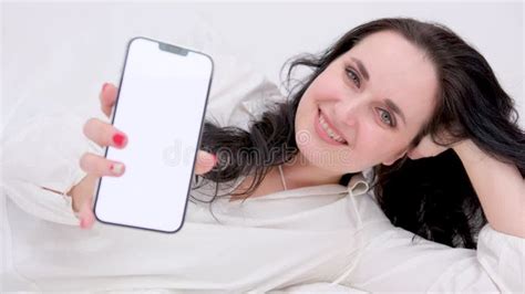 Top View Of Beautiful Brunette Woman Lying On White Silk Bed Using Smartphone Stock Video
