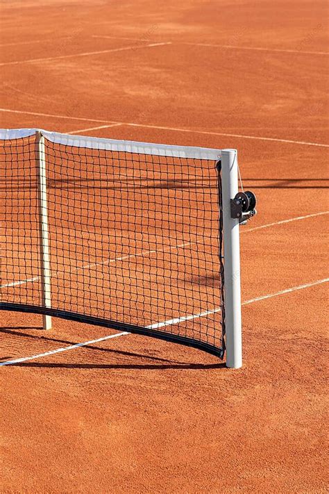 Fondo Cancha De Tenis De Tierra Batida Bañada Por El Sol Con La Línea De Base Y La Red A La