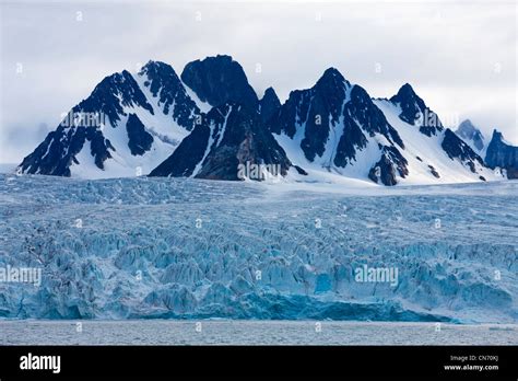 Norway, Svalbard, Spitsbergen Island, Mountain peaks rise above ice ...