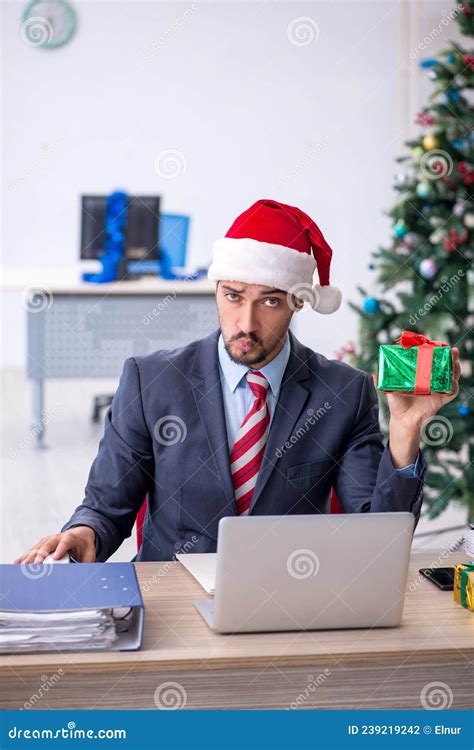 Young Male Employee Celebrating Christmas At Workplace Stock Photo