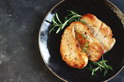 Filetes De Cerdo Fritos En Un Plato Negro Sobre Un Fondo Oscuro Con