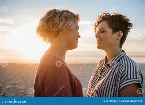 Young Lesbian Couple Enjoying A Romantic Beach Sunset Together Stock