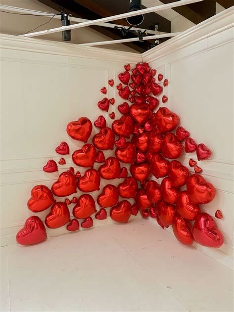 Many Red Hearts Are Arranged In The Shape Of A Triangle On A White Wall