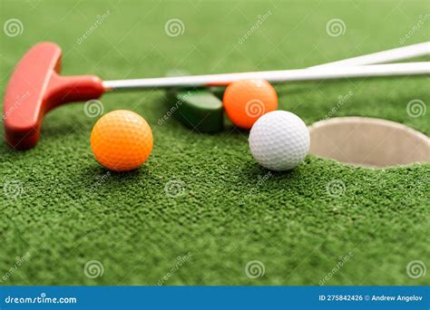 Mini-golf Clubs and Balls of Different Colors Laid on Artificial Grass ...